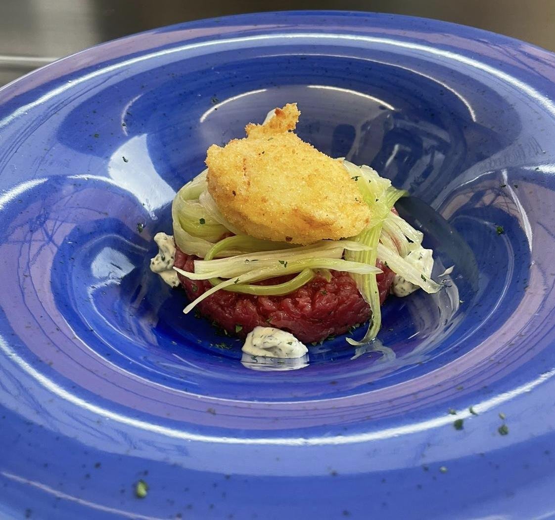 Tartare di Fassona 150 gr. al coltello, condita alla francese, rucola, uovo pochè e salsa tartara